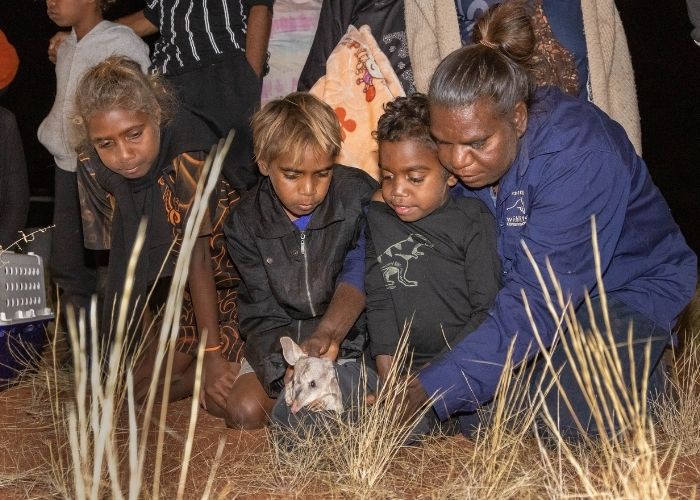 Christine Ellis, AWC Land Management Officer (right) joined by students from the local Nyirripi School help reintroduce the iconic Greater Bilby to its former range.
